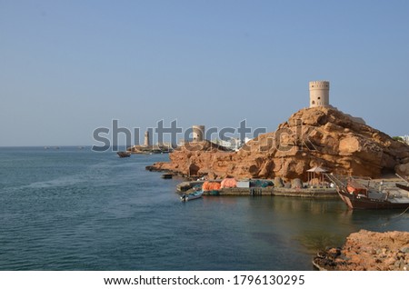 street along the beach of the Gulf of Oman, with the Eastern Hajar Mountains in the background Sur Lighthouse A docked dhow with Al-Ayjah Watchtower