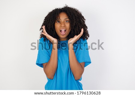 Surprised terrified african female isolated over white background. Gestures with uncertainty, stares at camera, puzzled as doesn't know answer on tricky question, People, body language, 