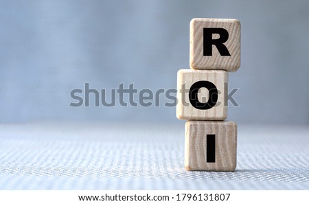 concept word ROI (Return On Investment) on wooden cubes on a gray background. Business concept Royalty-Free Stock Photo #1796131807
