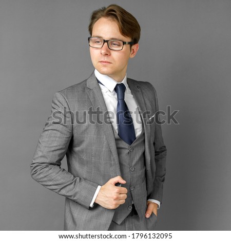 Portrait of a businessman in a suit who is looking to the side. Gray background concept of business and finance