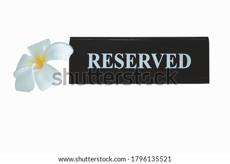 Reserved metal black plate in a restaurant. Reserved metal plate isolated on white background with clipping path. close up of a setting a reserved sign on the restaurant table.