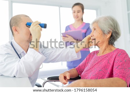 asian doctor use flashlight screening eyes of old asian patient, vision and cataract screening, elderly healthcare check up in hospital