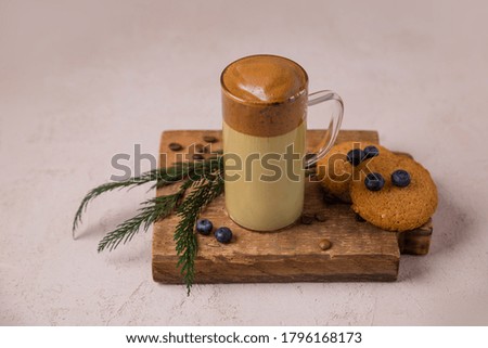 Korean coffee Dalgona Original colors, colored milk in a glass cup on a dark background with a place for the text Cookies, Christmas decoration 