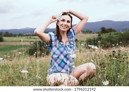 Woman smelling flowers in meadow adult caucasian woman in nature in countryside smelling white wild flowers on Zlatibor mountain in Serbia