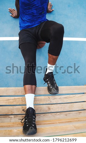 Black man sitting with the ball