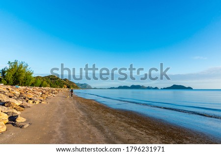 Sunrise scenery at sea beach and woman running with her dog.