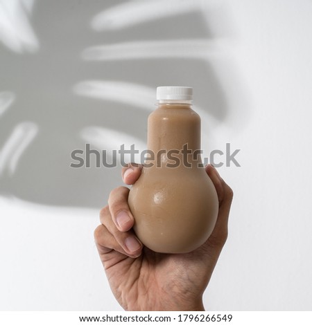 gesture of hand holding plastic bottle product mockup