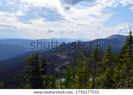 The top of a high mountain. Independent tourism. A sense of freedom and happiness.Mountain valley. Panoramic view of the mountains. Fascinating nature of Siberia.