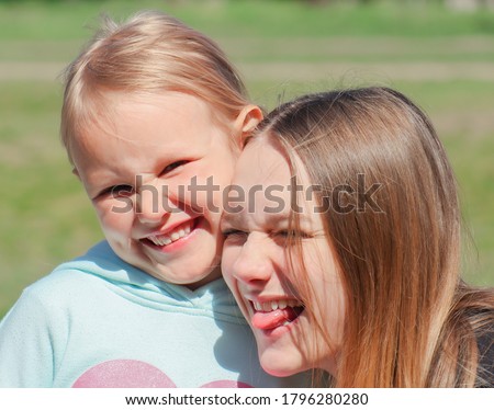 two cute young girls having fun smiling in nature