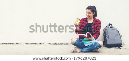 Asian young women reading book and drinking coffee on outdoor nature park for education. Education Concept, copy space for banner