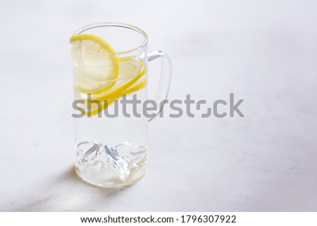 water with lemon Breakfast, fresh morning drink
Transparent glass with lemon wedges. light background copy space