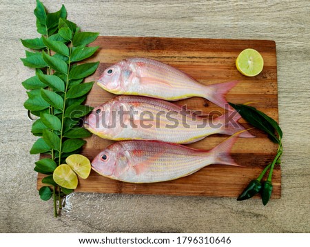  pink Perch fish with ingredients like lemon,curry leaves,chilli ,also known as kili meen .selective focus.
