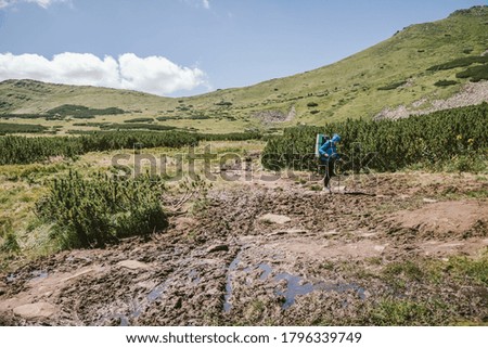 A person that is standing in the dirt with a mountain in the background