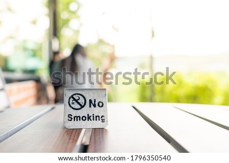 No smoking sign on wooden table in coffee shop.