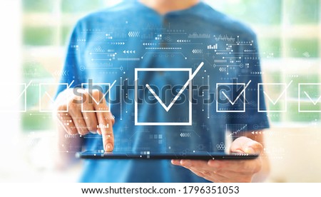 Checklist concept with young man using a tablet computer