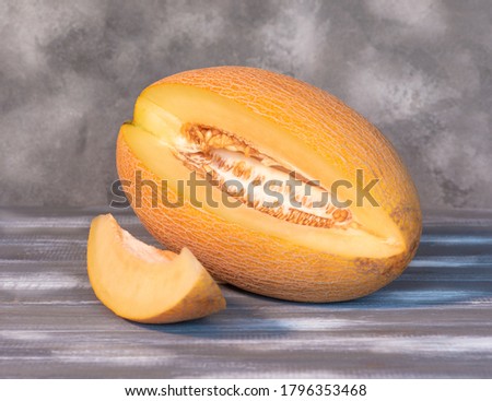 Fresh melon cut on a wooden background.
