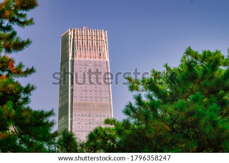 A skyscraper among green trees.