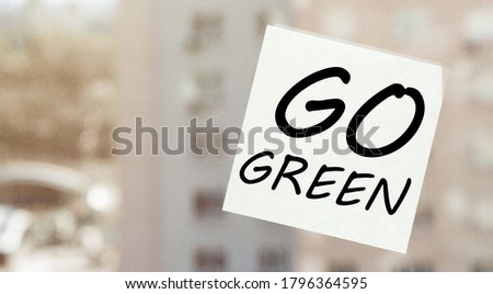 white paper with text Go Green on the window
