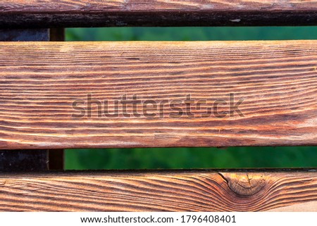 Zoom on a Wooden deck of a jetty in Lake Garda. The wood is warm, brown in color. Detail, macro picture with bokeh. Perfect for background.