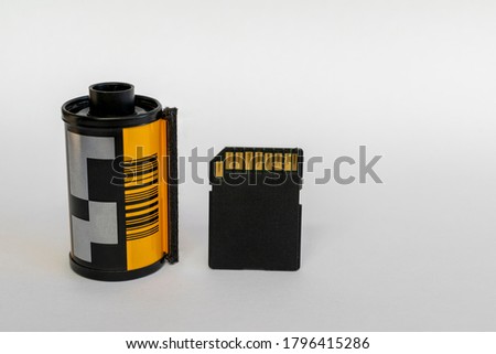 SD card for digital camera next to an old 35 mm film.