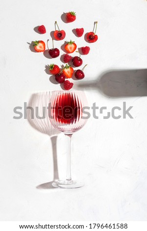 Concept composition presenting red wine flavours of summer fruits of berries on white background Royalty-Free Stock Photo #1796461588