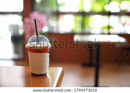 Picture of plastic coffee cups with white tissue paper  Located in a coffee shop  With blurred background  Is the atmosphere inside the coffee shop