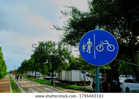 a blue circular sign indicating a pedestrian/bicycle road.