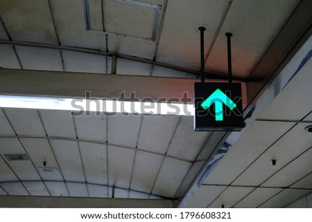 green arrow sign suspended from ceiling