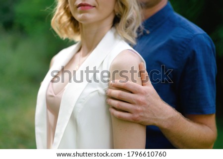 Young couple hugging. Man hugs a young woman by the shoulders, support. Wedding photo.