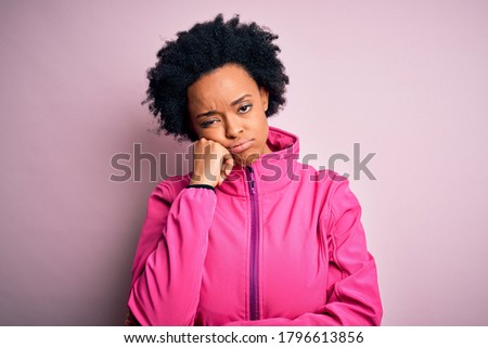 Young African American afro sportswoman with curly hair wearing sportswear doin sport thinking looking tired and bored with depression problems with crossed arms.