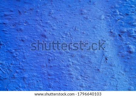Blue gradient paint on a stucco scratched wall. Close-up of a gr