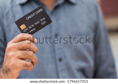 Close up businessman hand holding black credit card to Financial administration. Buying Shopping online, Internet banking concept.