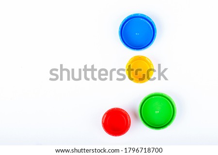 Group of multi colored bottle caps on a white background. Top view.