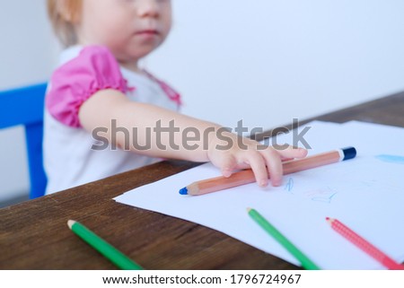 kid, baby draws doodles with colored pencils, concept of creativity, happy childhood, children's games, alpha generation