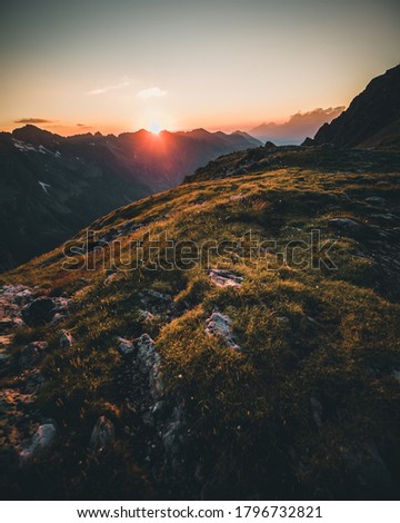 colorful sunset on top of austrian mountain alps