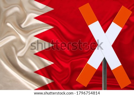 sign, stop, attention against the background of the silk national flag of Bahrain, the concept of border and customs control, violation of the state border, tourism restrictions
