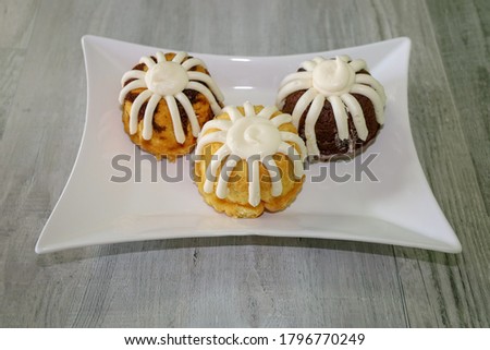Three mini muffin cakes with frosting.