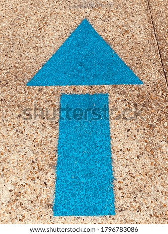 Directional signage with blue arrow on ground