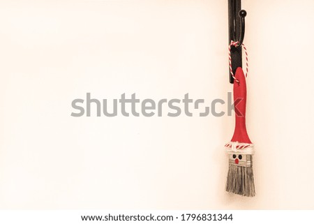 Hand-made Santa Claus from a paint brush hangs on a white background. Place for your text