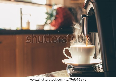 Close-up of coffee machine making steaming coffee on vintage kitchen. Early morning breakfast on rustic background, picture with copy space