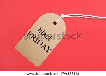 Tag with words BLACK FRIDAY on red background, top view