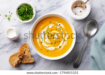 Pumpkin traditional soup with creamy silky texture. Marble background. Top view.