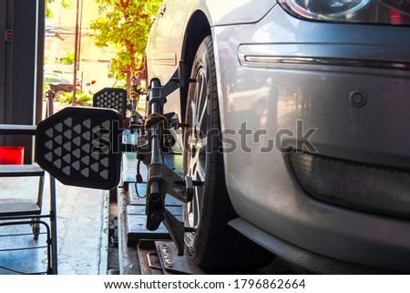 Set against the Center wheel, Wheel Aligner after replacing all 4 new tires. At a cheap tire repair shop Royalty-Free Stock Photo #1796862664