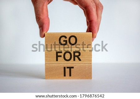 Male hand placing a block with word 'go' on top of a blocks tower with words 'go for it'. White table. Beautiful white background. Copy space. Business concept. Royalty-Free Stock Photo #1796876542