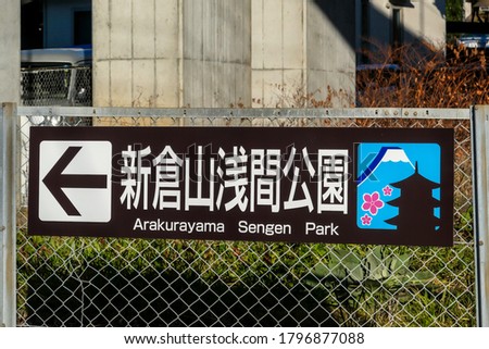 A sign attached to the fence leading to Arakurayama Sengen Park in Fujiyoshida, Japan. There is A small picture of Mount Fuji and Chureito Pagoda