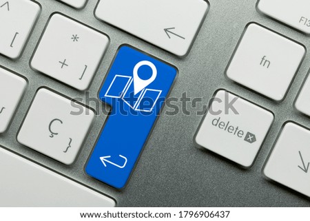 Map pin Written on Blue Key of Metallic Keyboard. Finger pressing key.