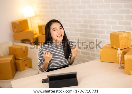 Worker In Warehouse Checking Boxes Using Digital Tablet.Start up small business entrepreneur SME or freelance  woman working  at home concept, Young Asian small business owner,online marketing.