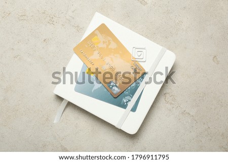 Notebook and credit cards on light background, top view