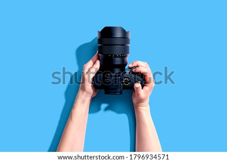 Person holding a SLR camera from above Royalty-Free Stock Photo #1796934571