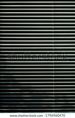 closed metal blinds jalousie with shadows ans sun light Royalty-Free Stock Photo #1796960470